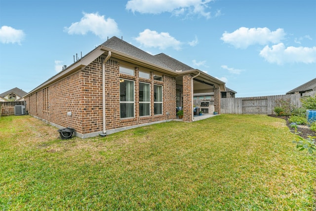 back of house with a yard, a patio, and central AC