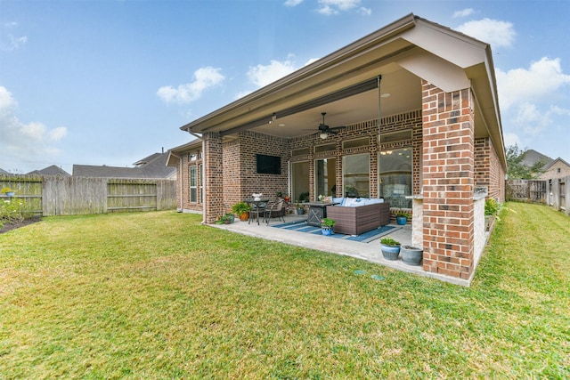 rear view of property featuring a lawn, a patio area, an outdoor living space, and ceiling fan