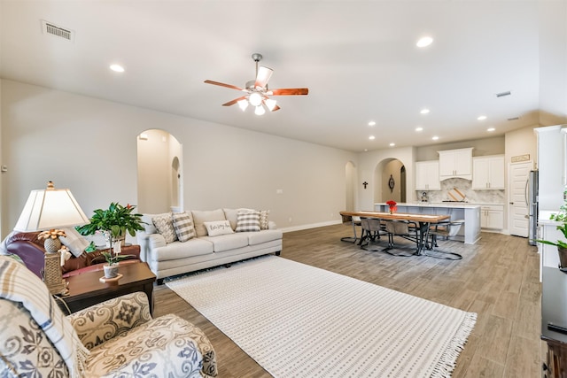 living room with ceiling fan and light hardwood / wood-style flooring