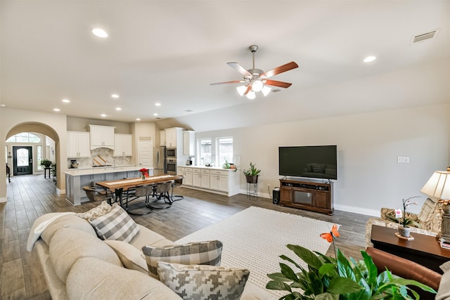 living room with dark hardwood / wood-style flooring, ceiling fan, and sink