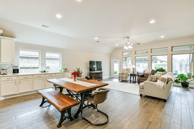 dining space with ceiling fan, a healthy amount of sunlight, and lofted ceiling