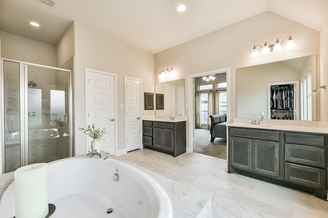 bathroom featuring plus walk in shower, vanity, and vaulted ceiling