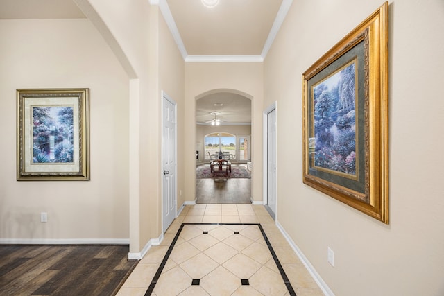 hallway with light tile patterned floors and crown molding