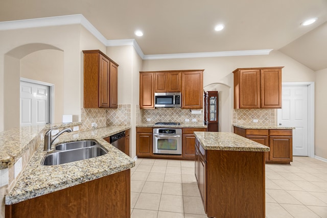 kitchen featuring kitchen peninsula, appliances with stainless steel finishes, tasteful backsplash, sink, and a kitchen island