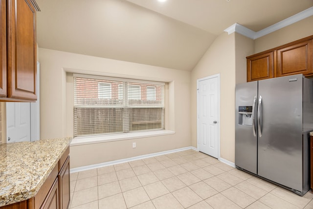 kitchen featuring light stone countertops, stainless steel refrigerator with ice dispenser, crown molding, vaulted ceiling, and light tile patterned floors