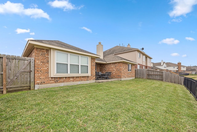 back of house with a yard and a patio