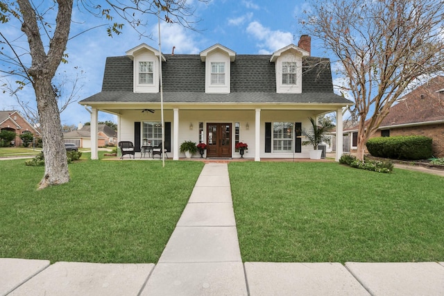 cape cod house with ceiling fan, covered porch, and a front lawn