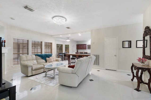 living room featuring a textured ceiling and light tile patterned floors