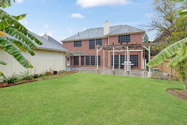 back of property with a yard, a pergola, and a patio area