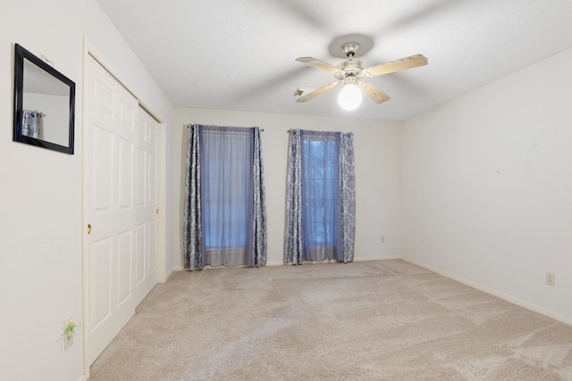 unfurnished room with light colored carpet and ceiling fan