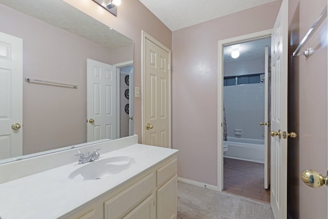 full bathroom featuring vanity, tiled shower / bath combo, toilet, and a textured ceiling