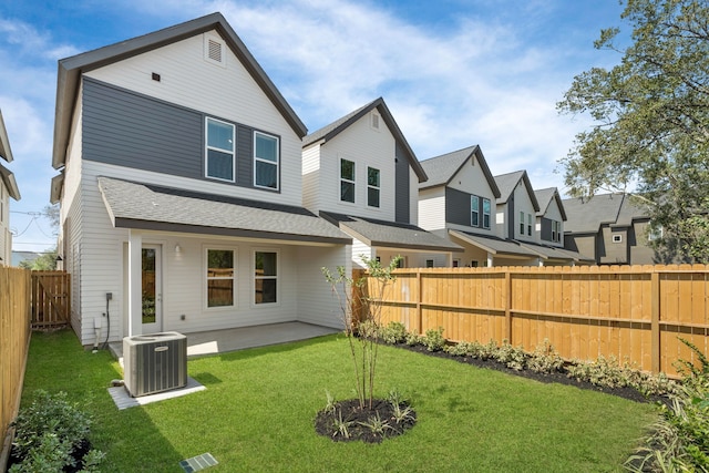 back of property with central AC unit, a patio area, and a yard