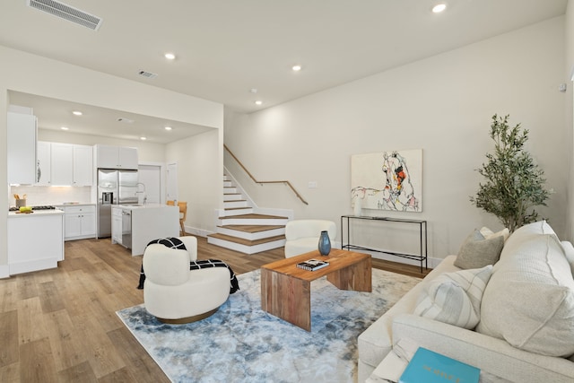 living room featuring sink and light hardwood / wood-style floors