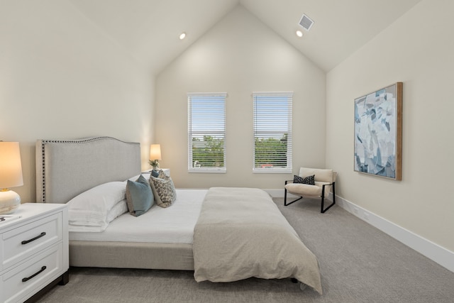 bedroom featuring light colored carpet and high vaulted ceiling