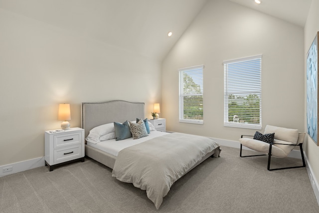 carpeted bedroom with high vaulted ceiling