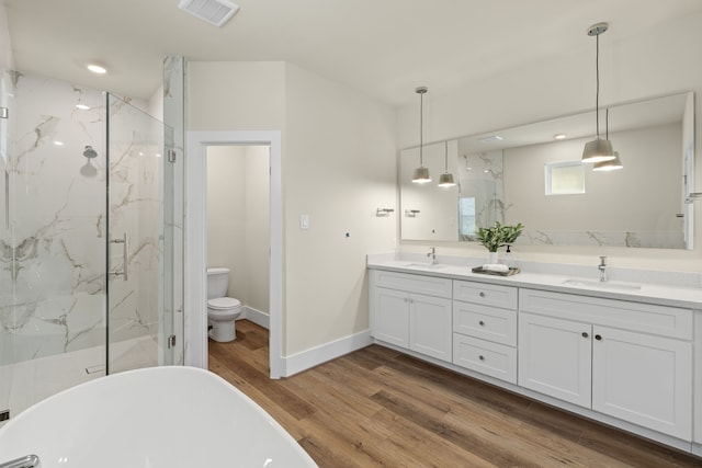 full bathroom with vanity, hardwood / wood-style flooring, independent shower and bath, and toilet