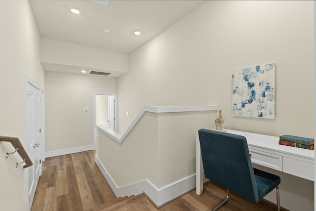 home office with built in desk and light wood-type flooring