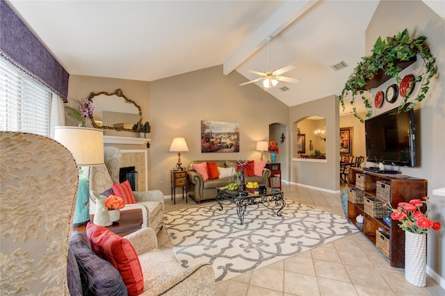 living room featuring a tile fireplace, lofted ceiling with beams, ceiling fan, and light tile patterned flooring