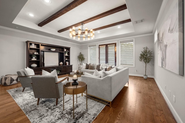 living room with hardwood / wood-style flooring, a notable chandelier, a raised ceiling, and ornamental molding