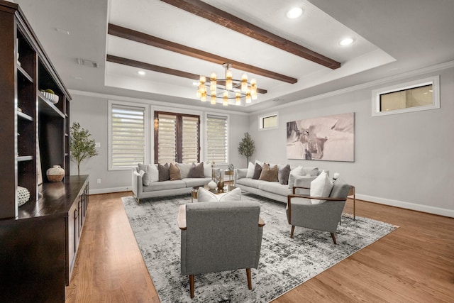 living room with a raised ceiling, hardwood / wood-style floors, and a notable chandelier