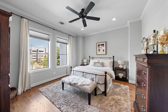 bedroom featuring ceiling fan, light hardwood / wood-style floors, and ornamental molding