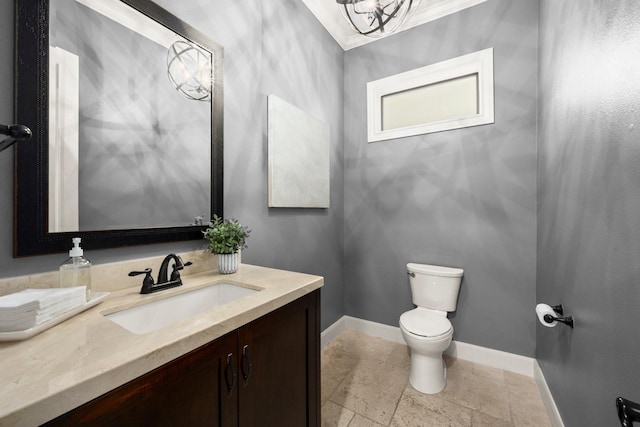 bathroom with an inviting chandelier, vanity, ornamental molding, and toilet