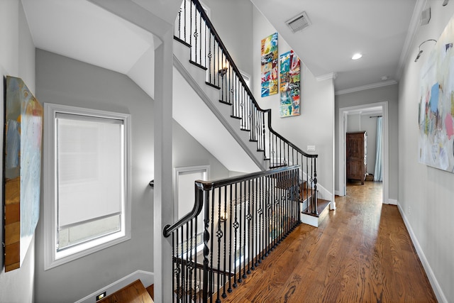 stairs featuring hardwood / wood-style flooring and crown molding