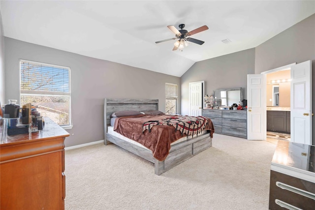 carpeted bedroom with ensuite bath, ceiling fan, and vaulted ceiling