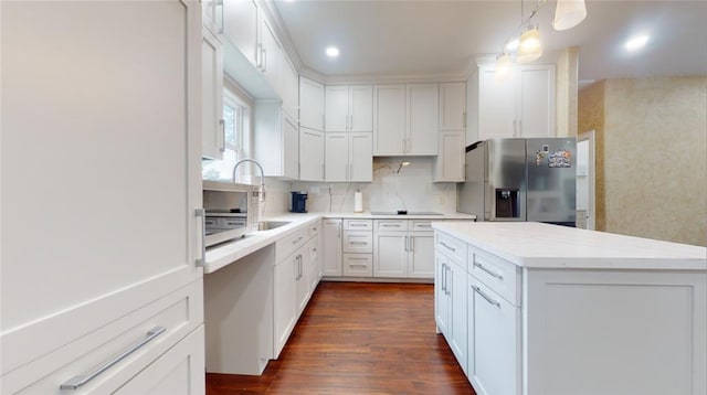 kitchen with stainless steel fridge, tasteful backsplash, dark wood-type flooring, decorative light fixtures, and white cabinets