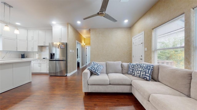 living room with ceiling fan and dark hardwood / wood-style flooring