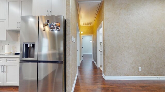 kitchen with white cabinets, dark hardwood / wood-style flooring, and stainless steel refrigerator with ice dispenser