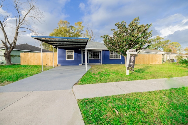 view of front of home with a carport and a front lawn