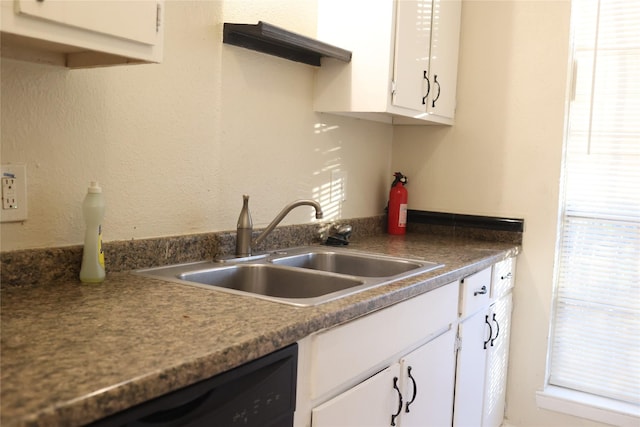 kitchen with dishwasher, white cabinetry, and sink