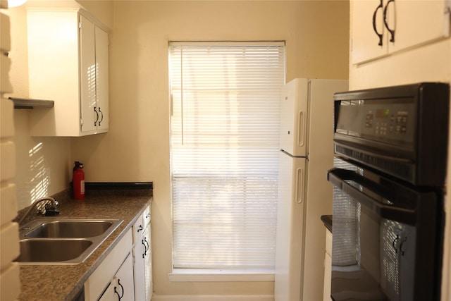 kitchen featuring white cabinets, white fridge, oven, and sink