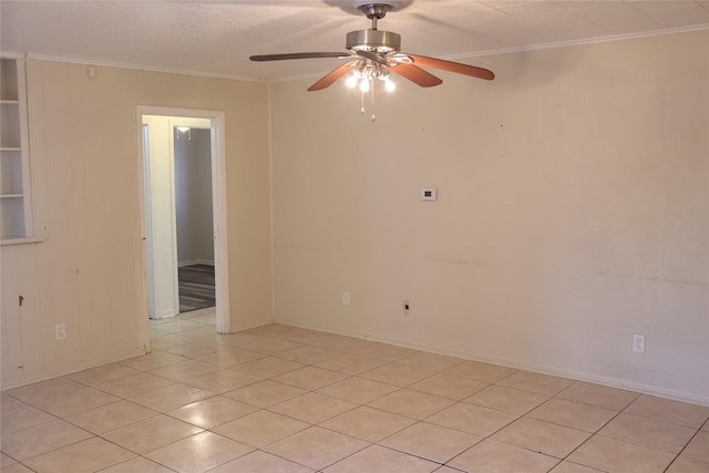 tiled empty room with ceiling fan and crown molding