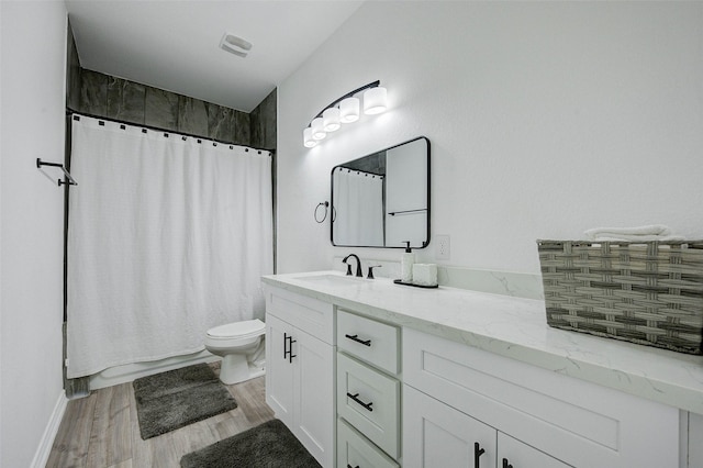 full bathroom featuring vanity, hardwood / wood-style floors, shower / tub combo, and toilet