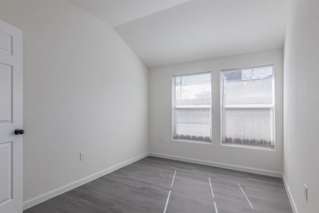 empty room featuring hardwood / wood-style flooring and vaulted ceiling