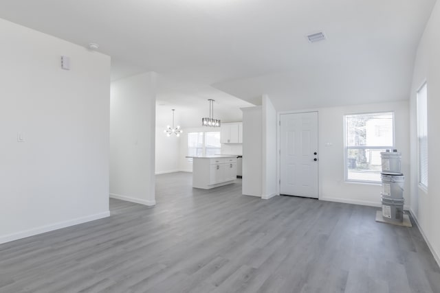 unfurnished living room with a chandelier and light hardwood / wood-style flooring