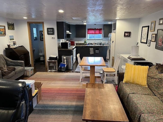 living room featuring dark hardwood / wood-style floors, sink, and a textured ceiling