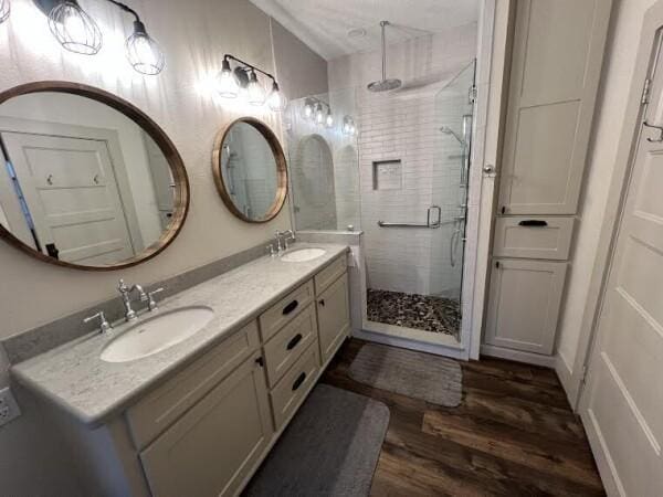 bathroom with hardwood / wood-style floors, vanity, and an enclosed shower