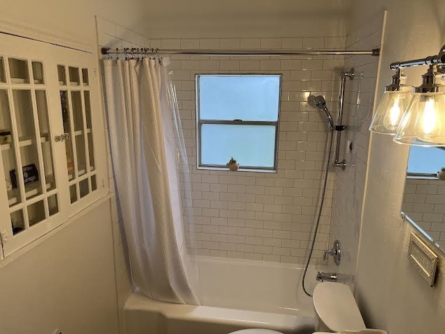 bathroom featuring plenty of natural light, toilet, and shower / tub combo