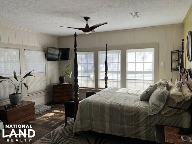 bedroom featuring ceiling fan, dark wood-type flooring, and a textured ceiling