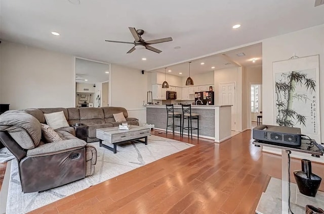 living room featuring light wood-type flooring and ceiling fan