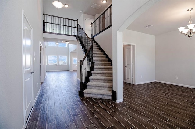 stairs with a high ceiling and an inviting chandelier