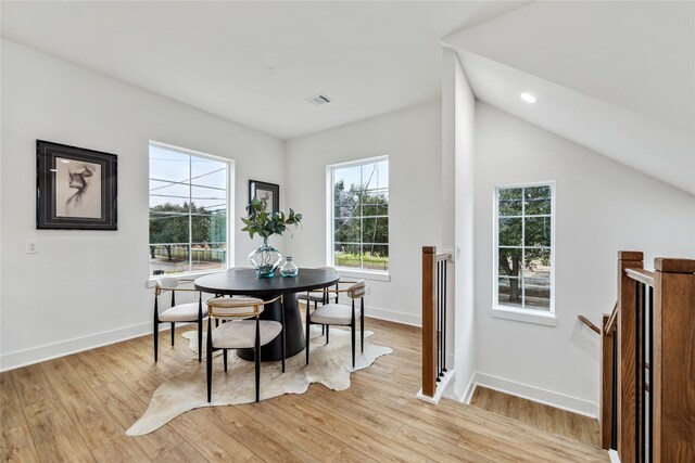 dining space featuring light hardwood / wood-style flooring and lofted ceiling