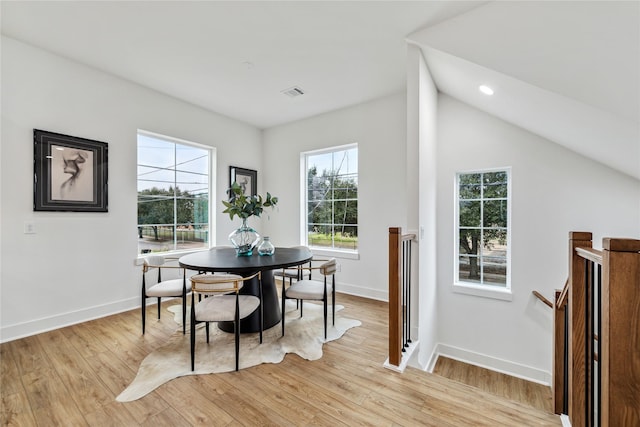 dining space featuring light hardwood / wood-style floors and vaulted ceiling