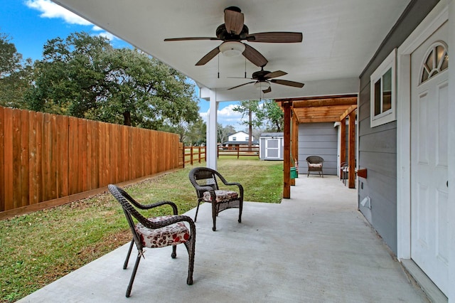 view of patio with ceiling fan and a storage unit