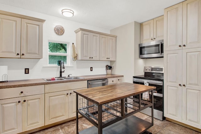 kitchen with sink, appliances with stainless steel finishes, and cream cabinets