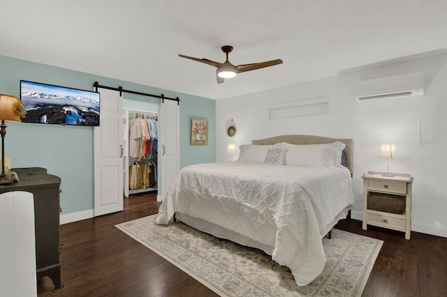 bedroom with ceiling fan, dark wood-type flooring, a wall unit AC, and a closet