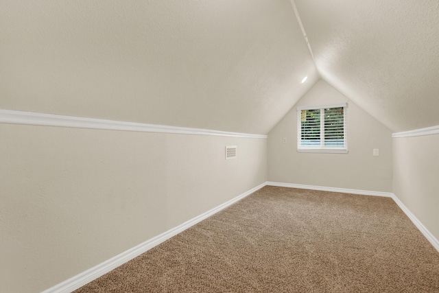 additional living space featuring carpet flooring and lofted ceiling